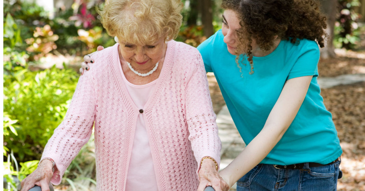 Teenage volunteer taking a walk with an older adult. Teenage volunteer taking a walk with an older adult.