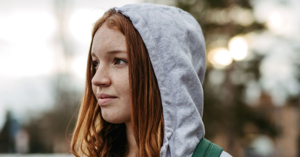 Gen Z young woman wearing a hoodie outdoors. Gen Z young woman wearing a hoodie outdoors.