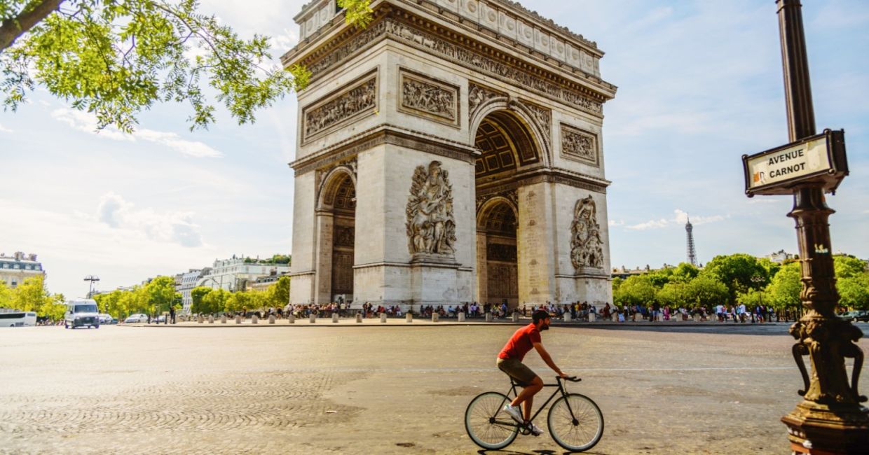 Man cycling near the Paris landmark Arc de Triomphe. Man cycling near the Paris landmark Arc de Triomphe.