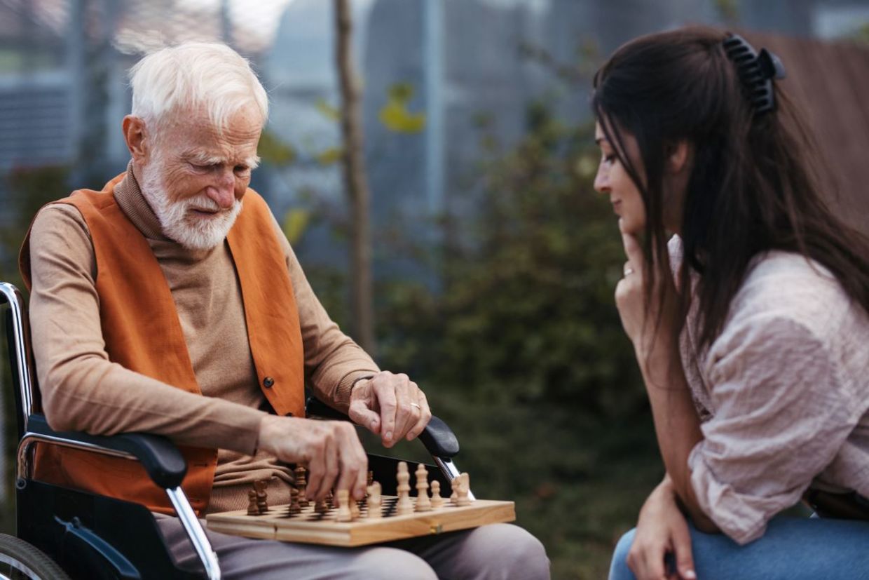 Patient young woman playing chess with a senior. Patient young woman playing chess with a senior.