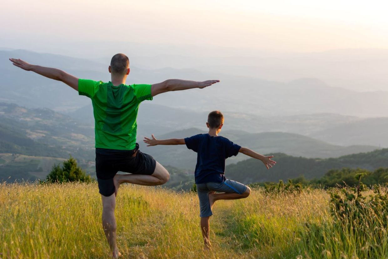 Father and son doing the tree pose. Father and son doing the tree pose.