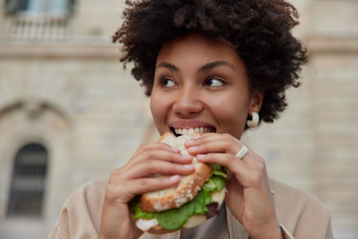 woman enjoying a sandwich for lunch. woman enjoying a sandwich for lunch.