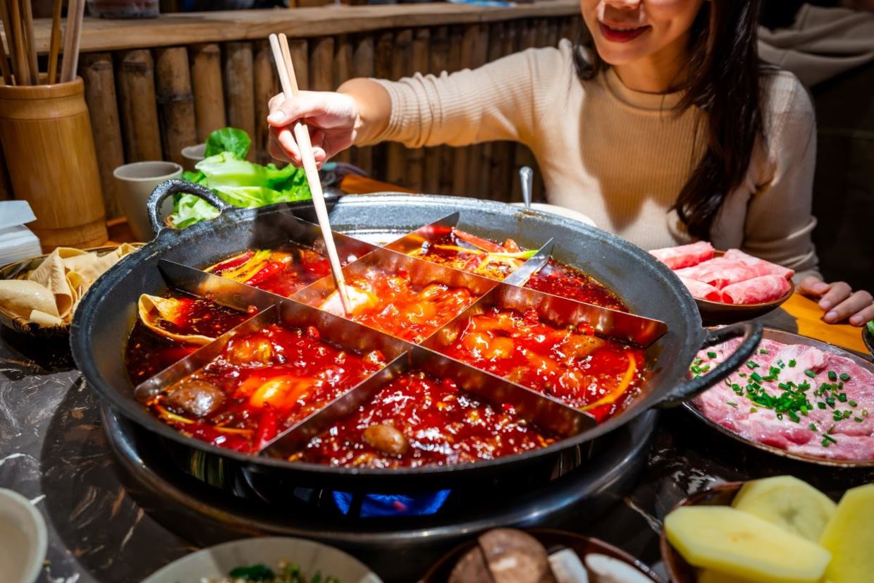 Woman eating original mala spicy hot pot Woman eating original mala spicy hot pot