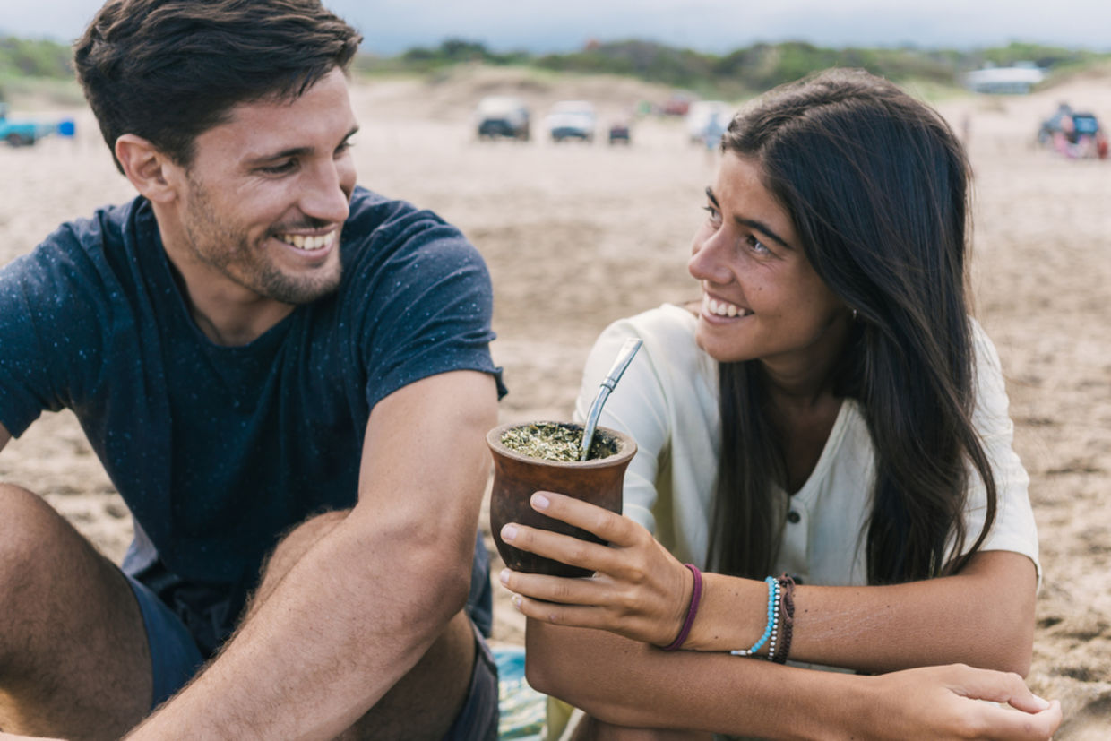A couple sharing Yerba mate tea in a gourd. A couple sharing Yerba mate tea in a gourd.