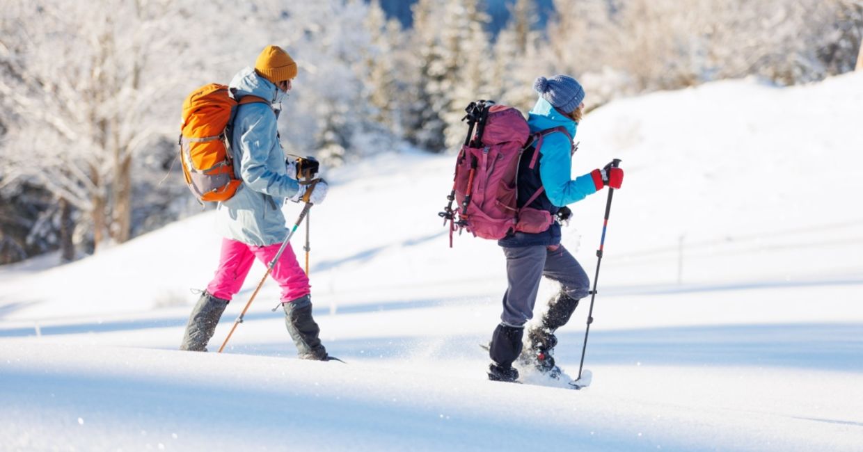 Two women winter hiking in snowshoes. Two women winter hiking in snowshoes.