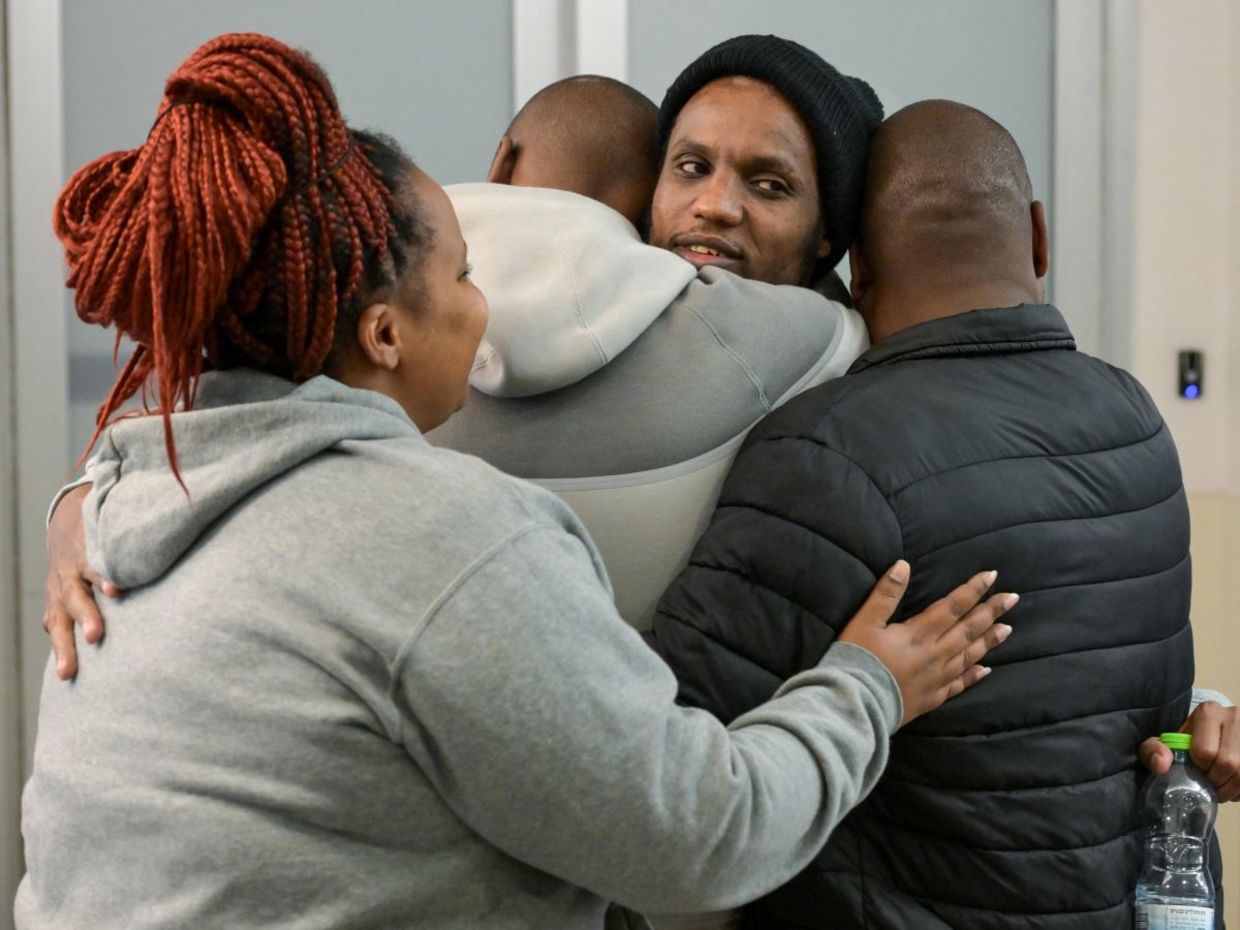Avera Mengistu embraces his family. Avera Mengistu embraces his family.
