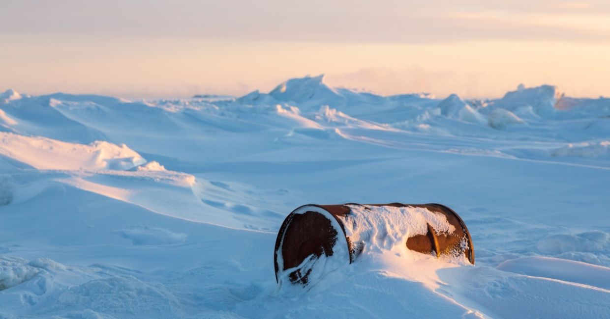 A rusty barrel on the shores of a frozen sea in the Arctic representing environmental pollution. A rusty barrel on the shores of a frozen sea in the Arctic representing environmental pollution.