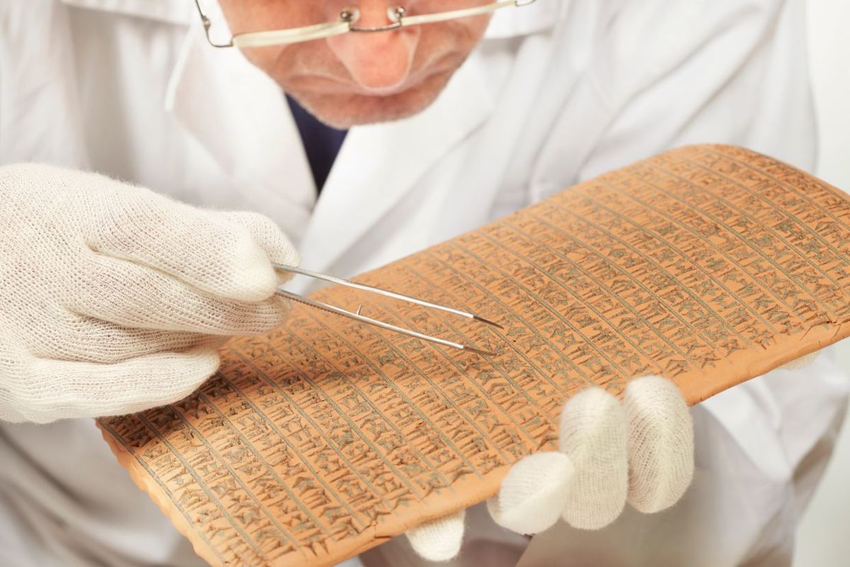Scientist exploring ancient cuneiform. Scientist exploring ancient cuneiform.