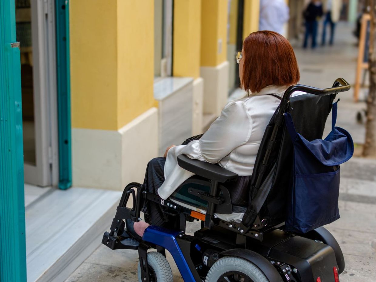 Woman cannot access a store that does not have a wheelchair ramp. Woman cannot access a store that does not have a wheelchair ramp.