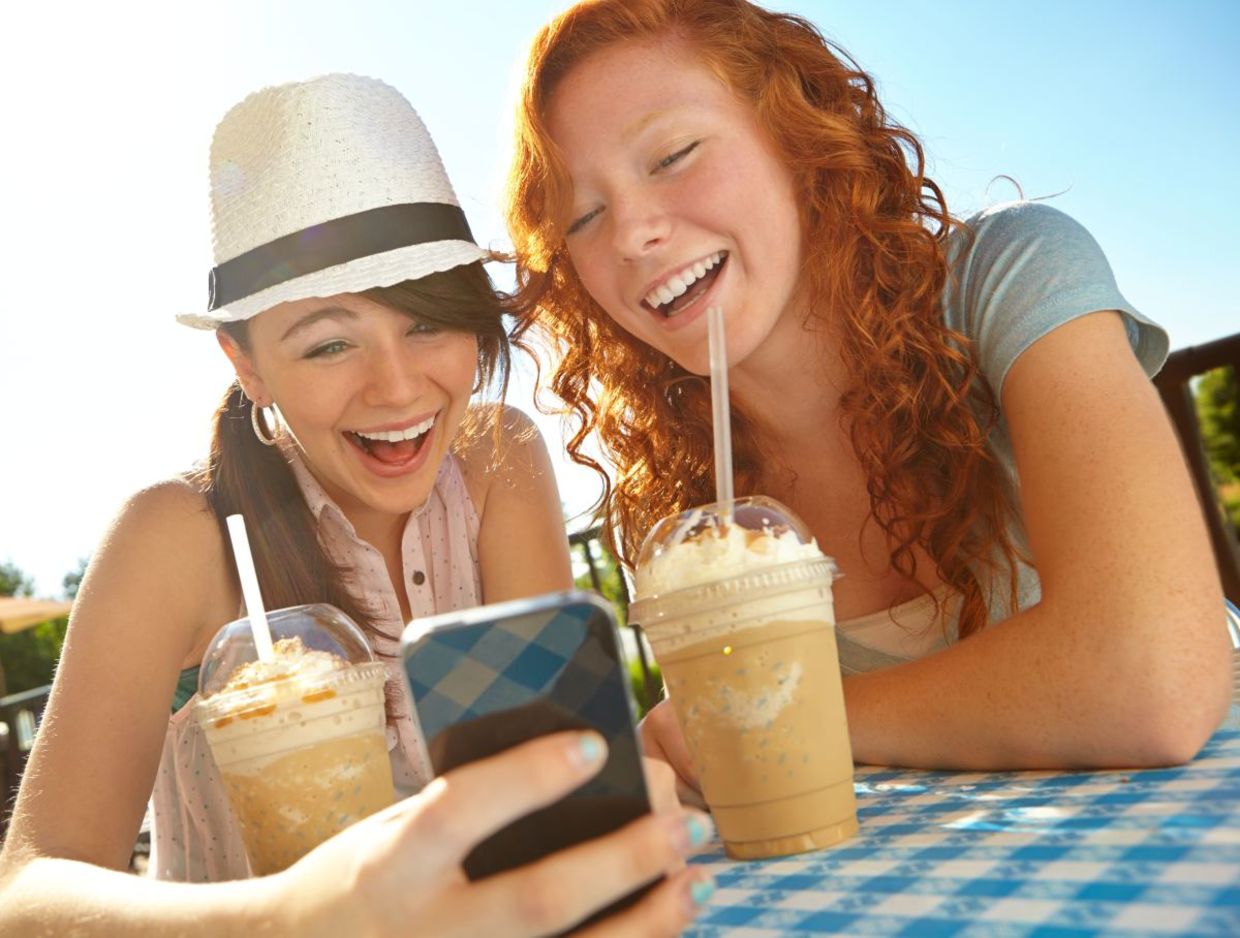 Two Gen Z friends enjoying iced coffee. Two Gen Z friends enjoying iced coffee.