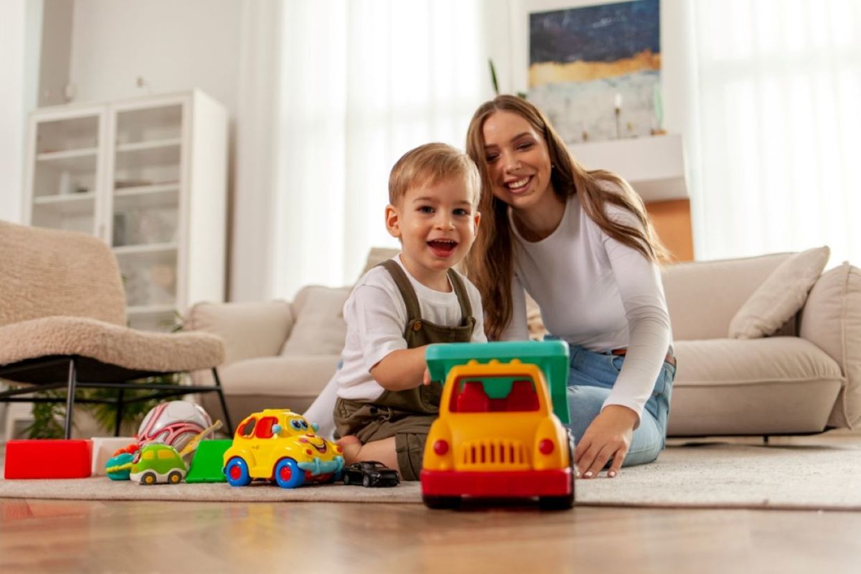 A kid plays with a toy car. A kid plays with a toy car.