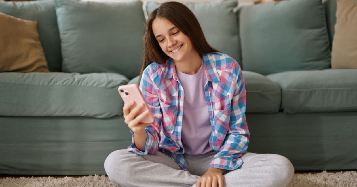 A teenage girl using an AI companion on her phone. A teenage girl using an AI companion on her phone.